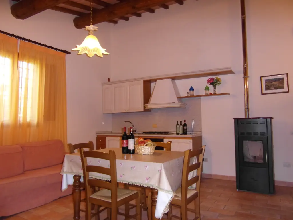 Zona giorno della Suite 14 Family con tavolo da pranzo e stufa a pellet